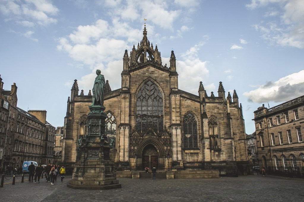 A large cathedral with spires and a statue of a man in front