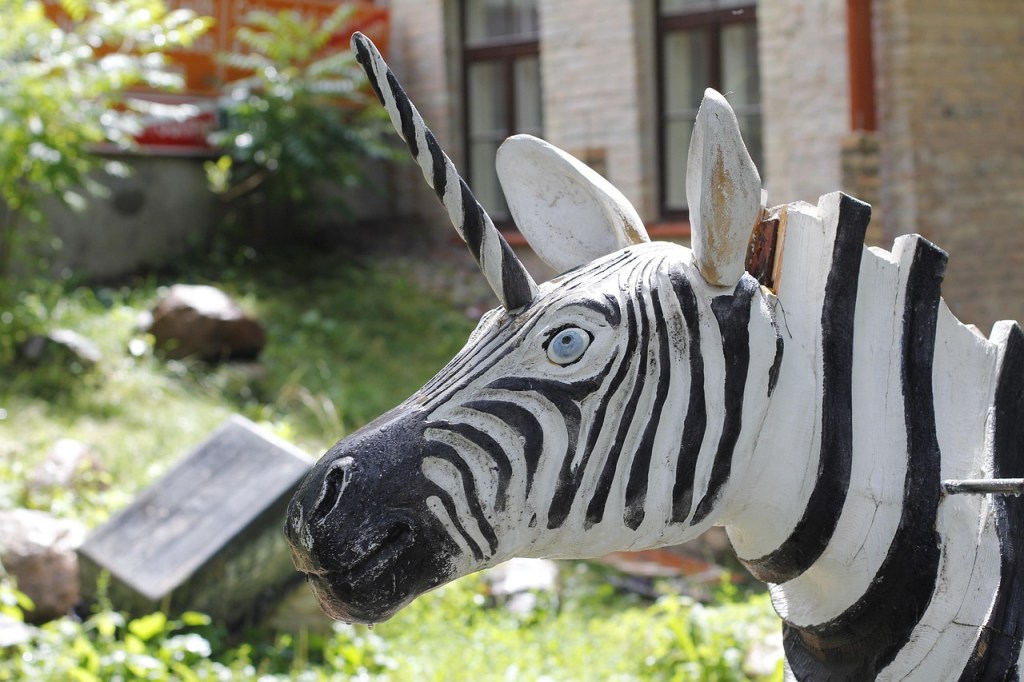 The head of a zebra with a unicorn horn